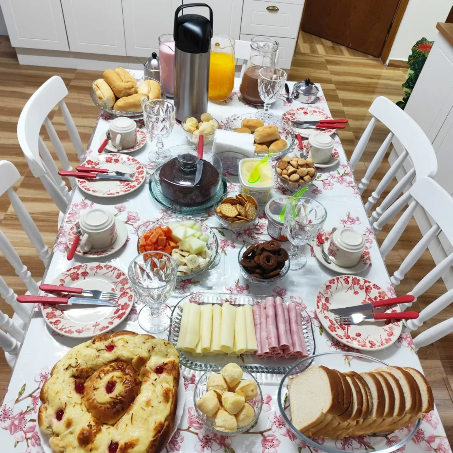 Mesa do café da manhã da Casa Sonata, com pães, bolo, frios e frutas